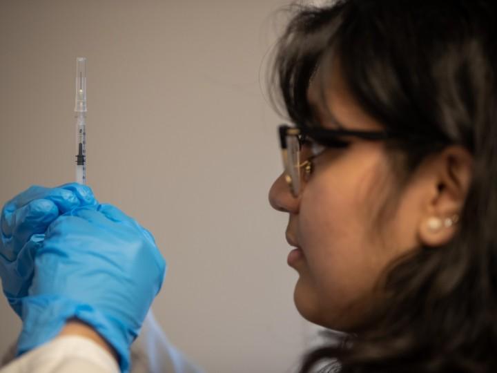 A pharmacist is administering a vaccine to patient